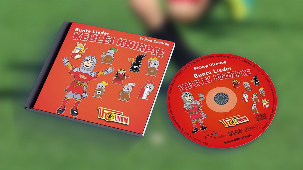 CD-Cover mit dem Titel "Keules Knirpse", illustriert mit bunten Figuren und einem Fußballmotiv, vor einem Unschärfe-Hintergrund.
