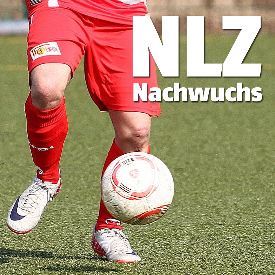 Ein Spieler in roter Fussballkleidung dribbelt den Ball auf einem Kunstrasenplatz.