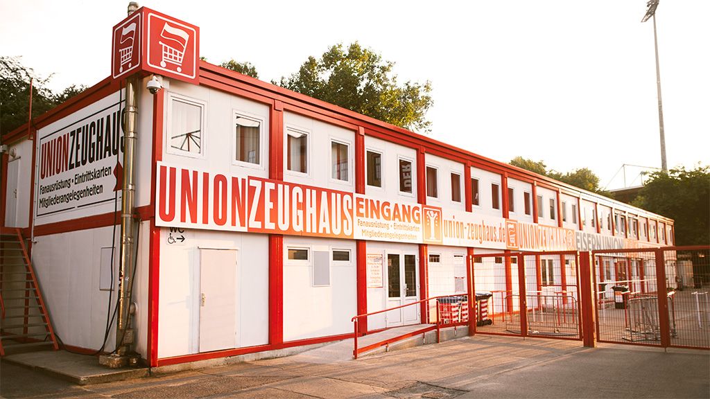 Eingangsbereich des Unionzeughauses mit roten und weißen Wänden und großen Werbeschildern.