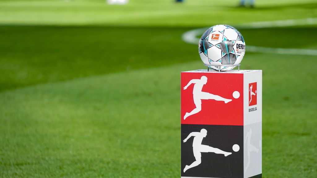 Ein Fußball auf einem Podest mit dem Logo der Bundesliga, im Hintergrund grüner Rasen.