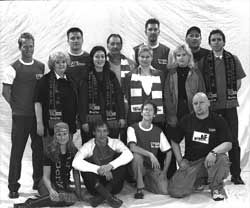 Eine Gruppe von 15 Personen in Freizeitkleidung, die vor einem weißen Hintergrund posiert.