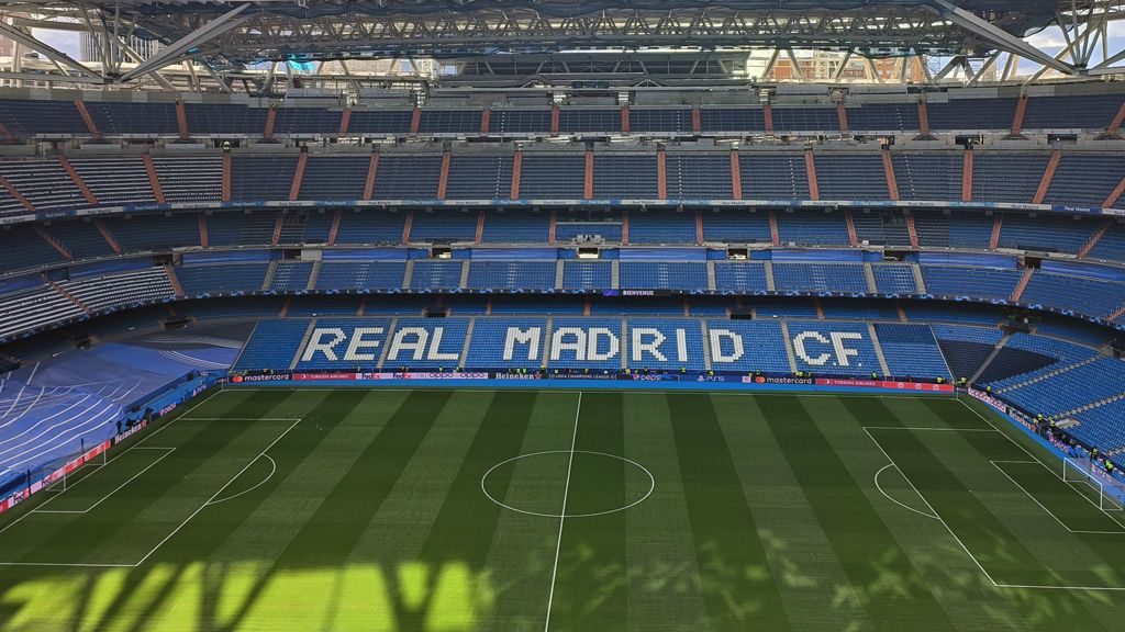 Blick auf das Santiago Bernabéu Stadion mit der Aufschrift "REAL MADRID CF" auf den Sitzen.