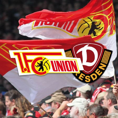 Fahnen von 1. FC Union Berlin und Dynamo Dresden im Stadion, umgeben von jubelnden Fans.
