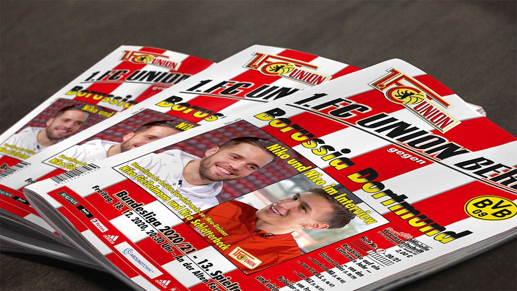 Zwei Stapel von Programmheften für ein Fußballspiel zwischen 1. FC Union Berlin und Borussia Dortmund.