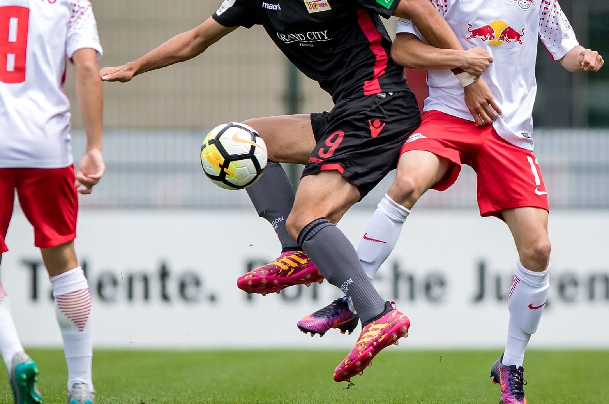 Zwei Fußballspieler im Wettkampf um den Ball während eines Spiels auf dem Spielfeld.