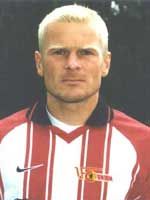 Porträt eines Fußballspielers mit blonden Haaren, in gestreifter Sportkleidung und neutralem Gesichtsausdruck.