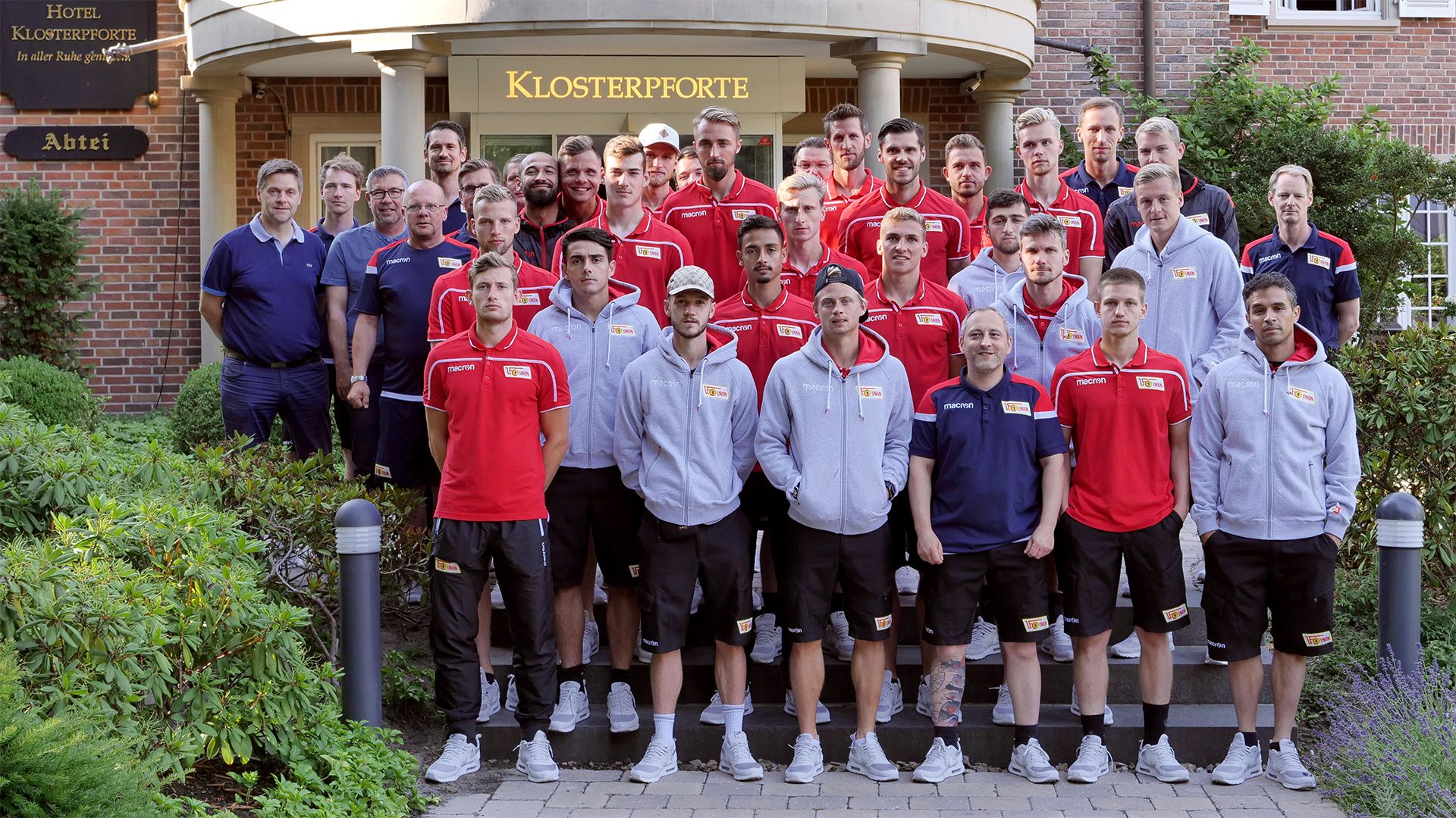 Mannschaftsfoto einer Sportmannschaft vor dem Hotel Klosterpforte, alle in einheitlicher Sportkleidung.