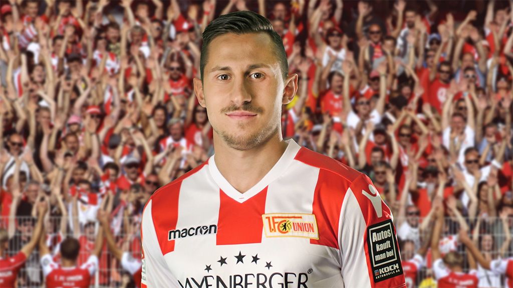 Spieler von Union Berlin in einer Rot-Weiß-Uniform vor jubelnden Fans im Hintergrund.