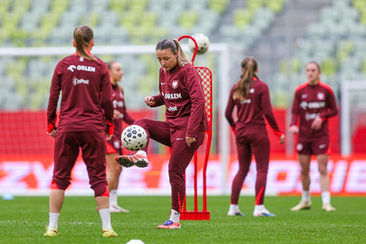 Frauenfußballmannschaft beim Training, eine Spielerin jongliert den Ball, andere Spielerinnen im Hintergrund üben mit Trainingseinheiten.