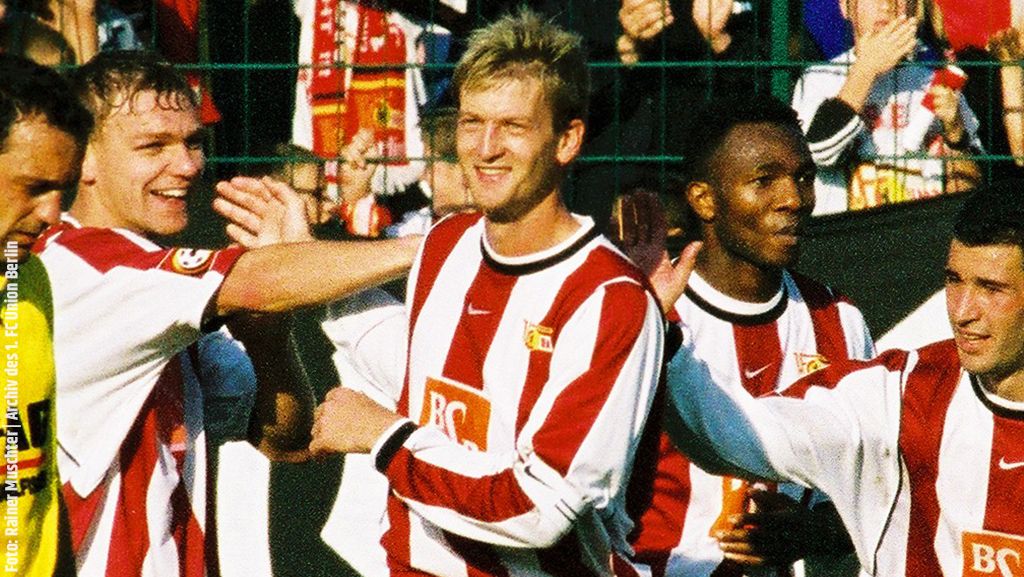 Football players in red and white jerseys celebrate together on the field.