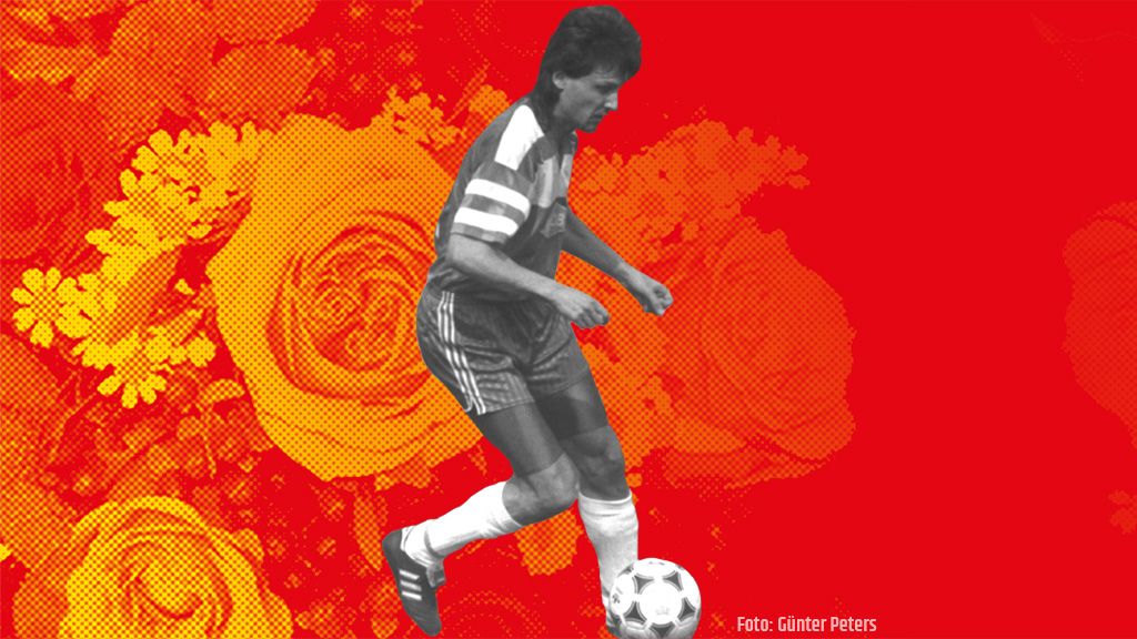 Ein Fußballspieler dribbelt den Ball auf einem roten Hintergrund mit orangefarbenen, grafischen Rosen.