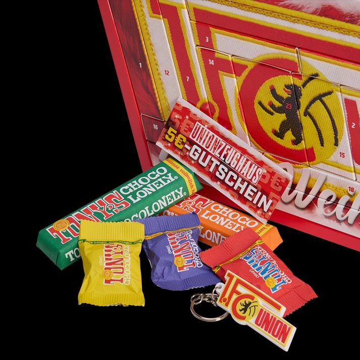 Ein Adventskalender mit verschiedenen Schokoladenriegeln und einem Gutschein, dekoriert mit roten und gelben Farben.