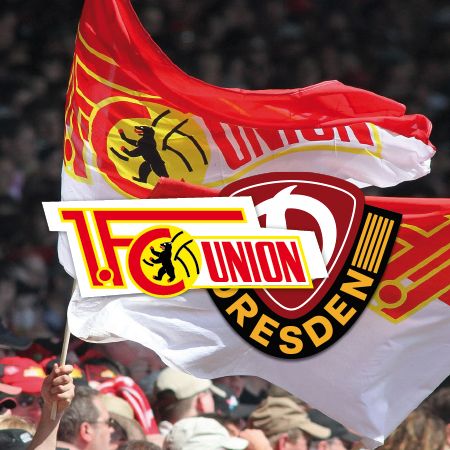 Fans mit Fahnen in den Farben Rot und Gelb, die die Logos von 1. FC Union Berlin und Dynamo Dresden zeigen.