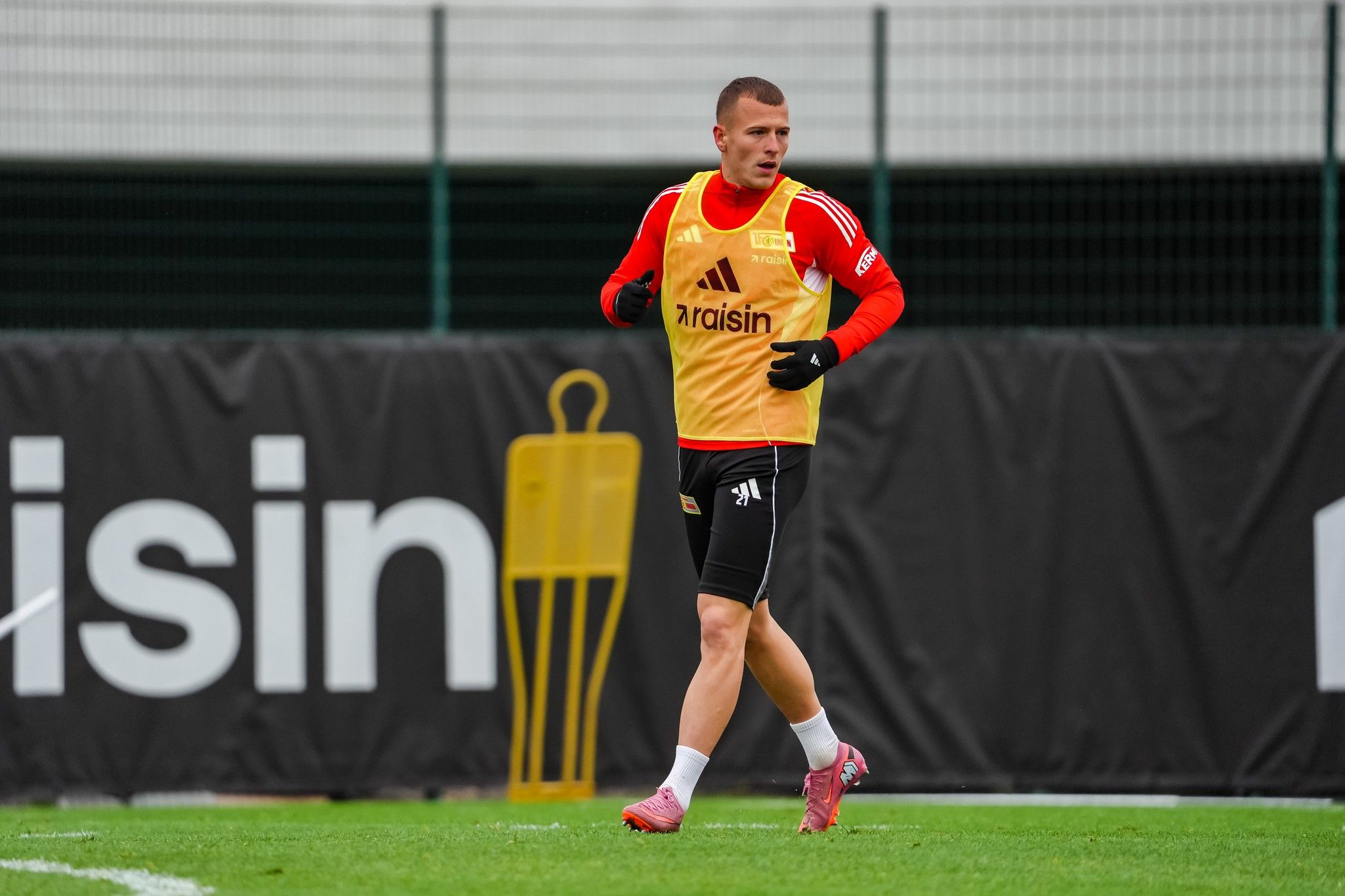 Ein Fußballspieler in Trainingskleidung läuft auf einem Rasenplatz während einer Übungseinheit.