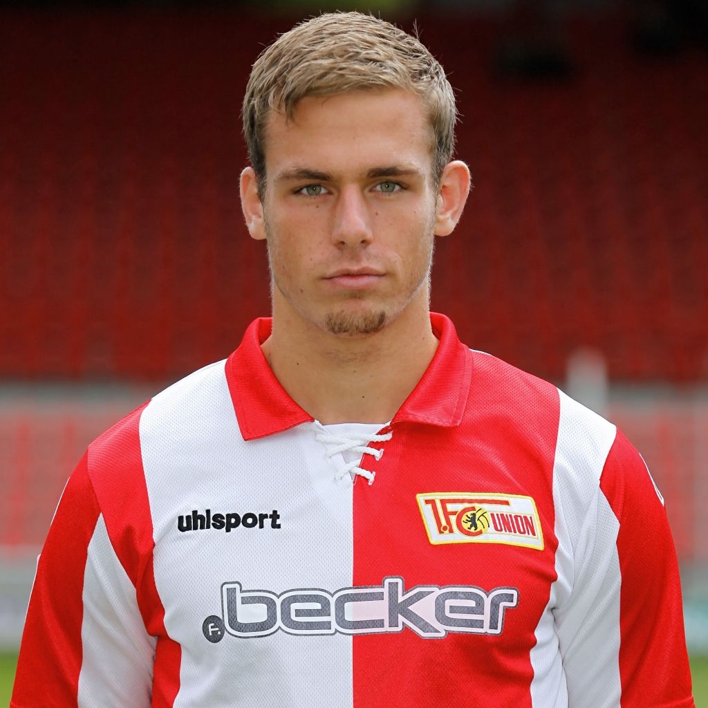 Junger Mann mit kurzen, blonden Haaren trägt ein rot-weißes Fußballtrikot mit dem Logo von 1. FC Union Berlin.