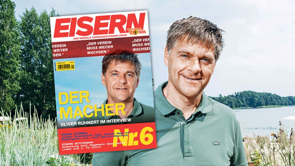Mann mit kurzen Haaren steht im Freien vor einer Zeitschrift mit dem Titel "EISERN" und einem Interview über ihn.