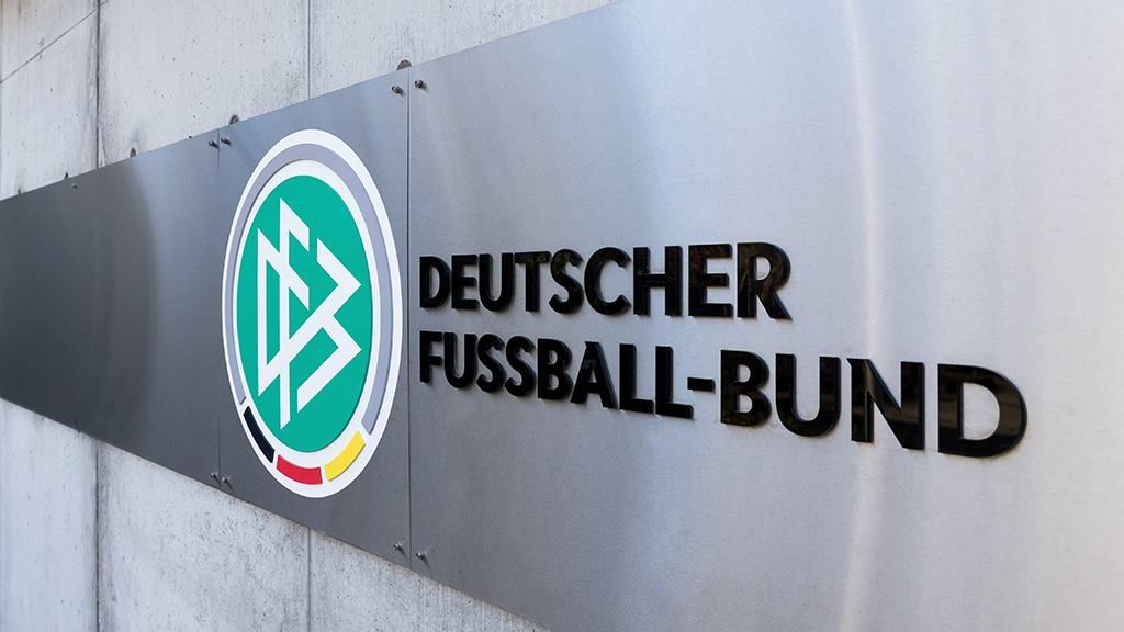 Logo of the German Football Association on a metal plaque on a wall.