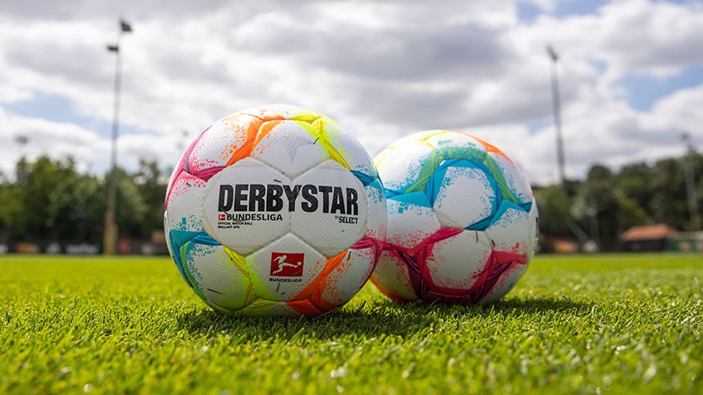 Zwei bunte Fußball mit dem Schriftzug "DERBYSTAR" und "BUNDESLIGA" liegen auf einem grünen Rasenfeld.