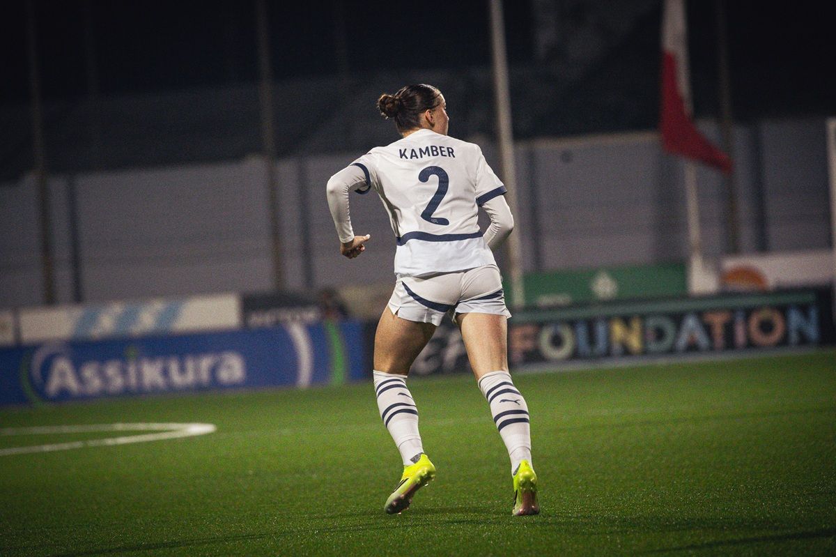 Frau in Sportkleidung mit der Nummer 2 läuft auf einem Fußballfeld.