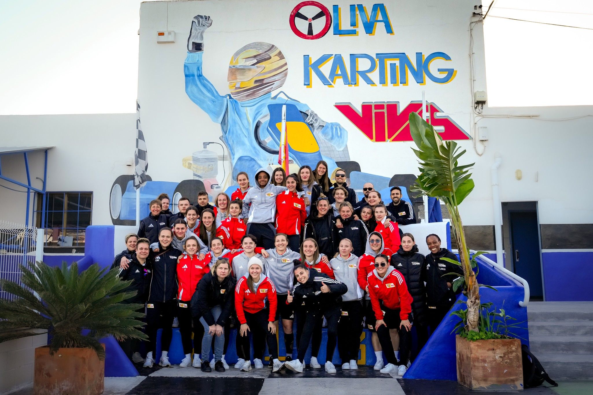 Gruppenfoto von Personen vor einer Wand mit einem Karting-Motiv und dem Schriftzug "LIVA KARTING".
