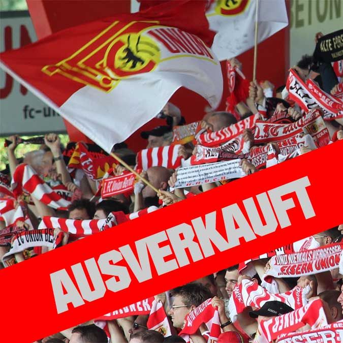 Fans eines Fußballteams jubeln in einem Stadion, umgeben von Fahnen und Schals, mit dem Schriftzug „AUSVERKAUFT“ in großen Buchstaben.