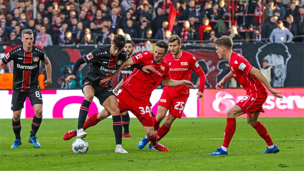 Game scene in the football match between Bayer Leverkusen and Union Berlin with several players fighting for the ball.