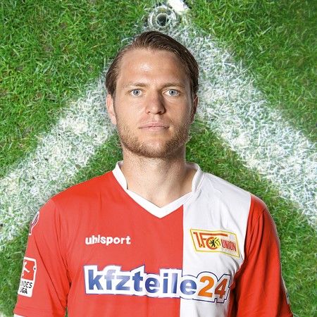 Spieler des Fußballvereins 1. FC Union Berlin im Trikot mit Logo und Gras-Hintergrund.