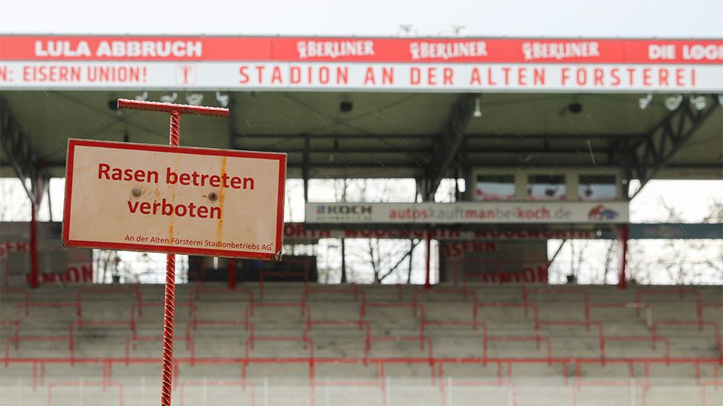 Ein Schild mit der Aufschrift "Rasen betreten verboten" im Stadion an der alten Försterei. Im Hintergrund leere Sitzplätze.