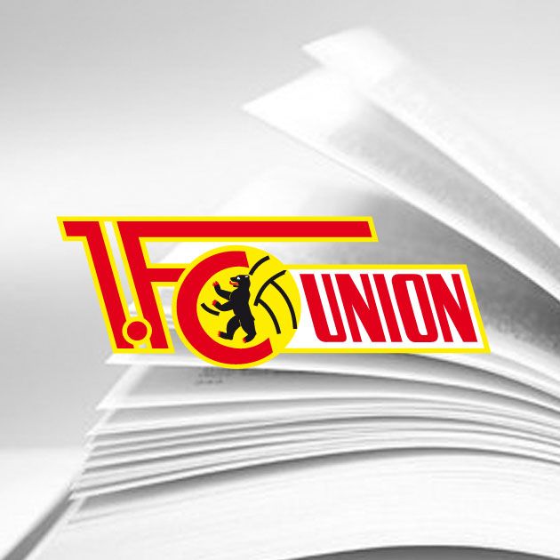 Logo des 1. FC Union Berlin auf einem verschwommenen Hintergrund mit aufgeschlagenem Buch.