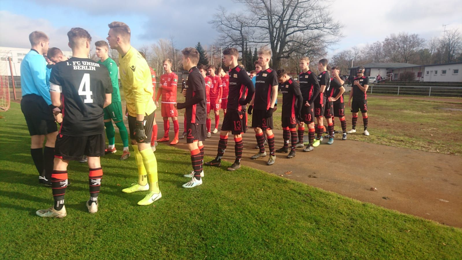 Zwei Fußballmannschaften stehen sich auf einem Spielfeld gegenüber, bereit für ein bevorstehendes Spiel.
