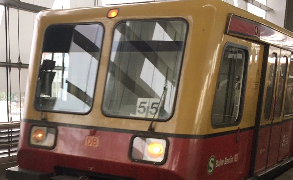 Zug der S-Bahn Berlin mit gelbem und rotem Design, an einer Haltestelle abfahrbereit.