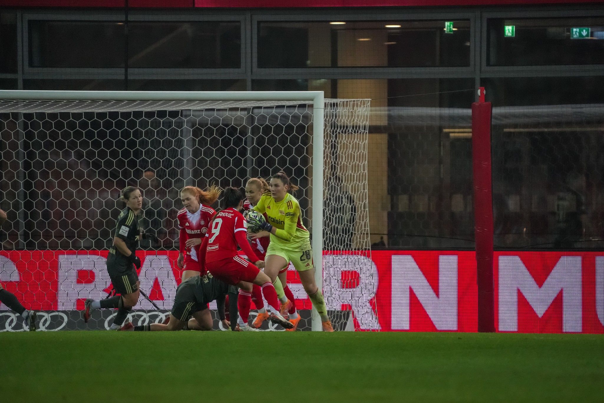Spielszene im Fußball mit mehreren Spielerinnen im Strafraum, eine Torhüterin bereitet sich auf einen Schuss vor.