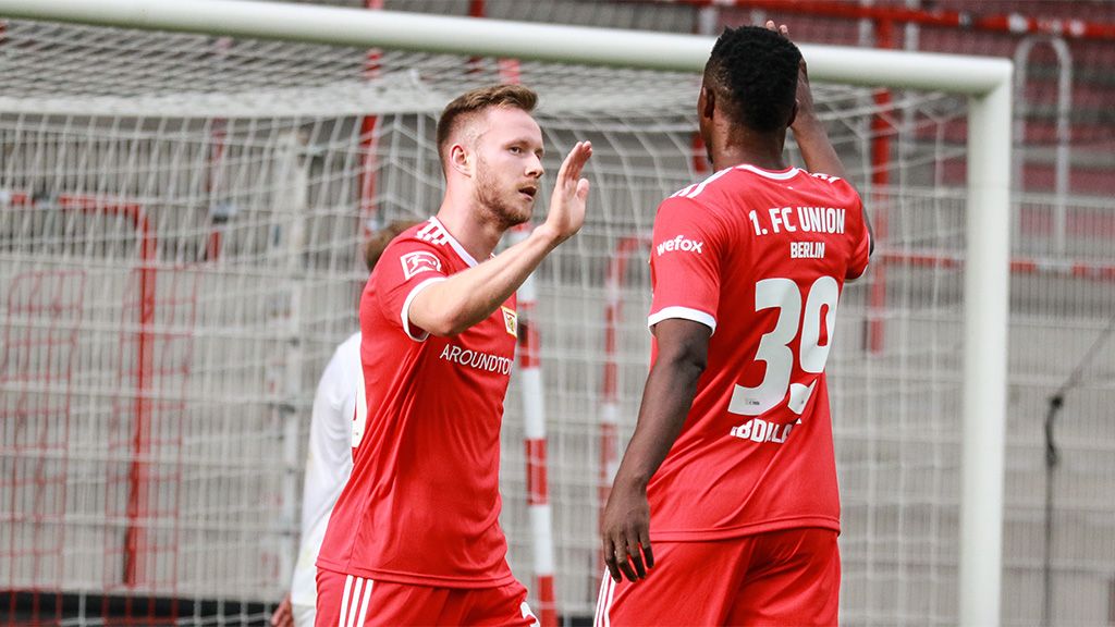 Zwei Spieler des 1. FC Union Berlin jubeln nach einem Tor in einem Stadion.