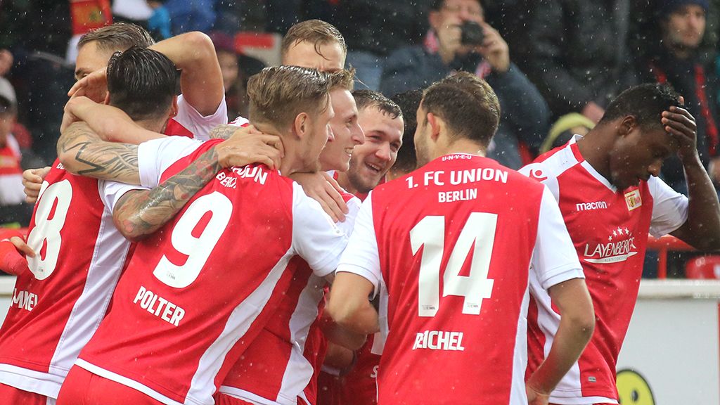 Die Spieler vom 1. FC Union Berlin feiern ein Tor. Es regnet.