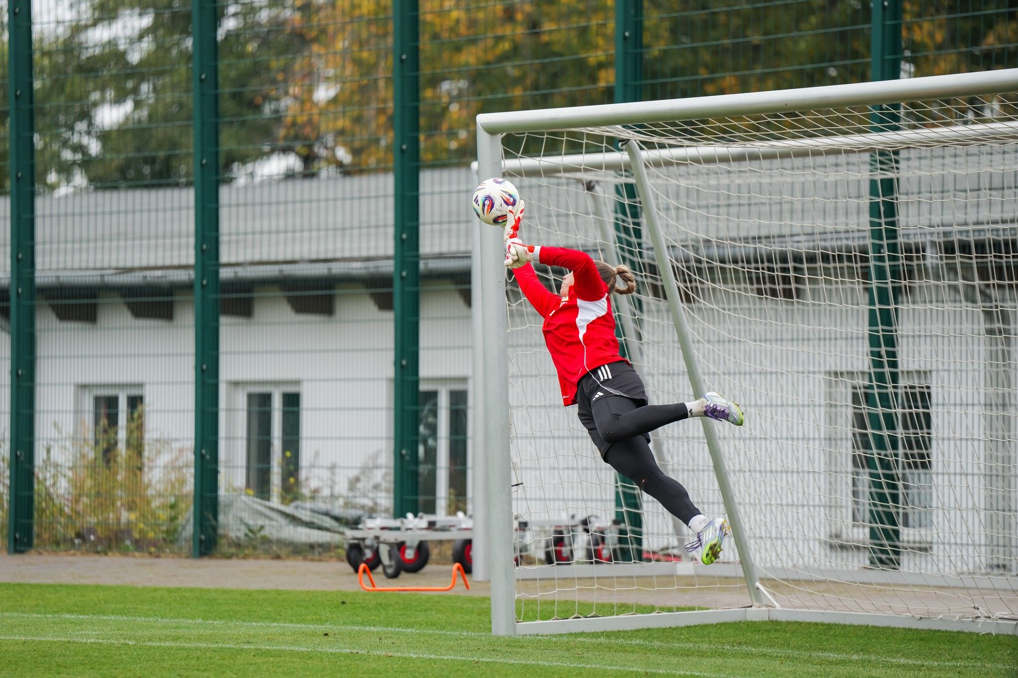 Torwart springt, um einen Schuss auf das Tor mit einer Fußball zu parieren.