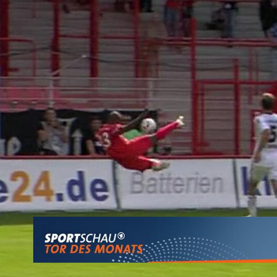 Ein Fußballspieler führt einen spektakulären Fallrückzieher aus, um den Ball ins Tor zu befördern.