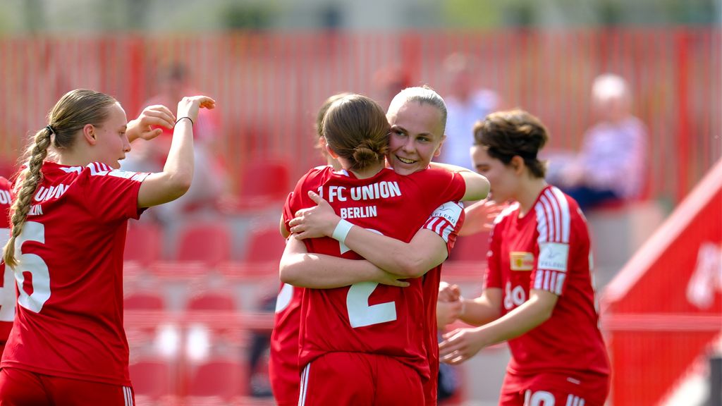 Spielerinnen des FC Union Berlin feiern einen Treffer und umarmen sich auf dem Spielfeld.