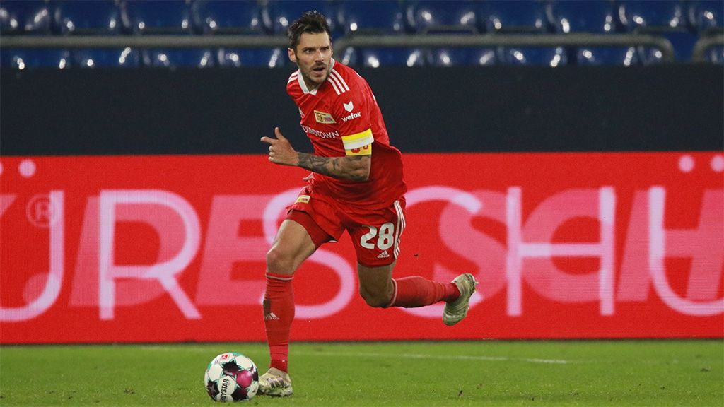 Ein Spieler in rotem Trikot mit der Nummer 28 läuft während eines Fußballspiels mit einem Ball.