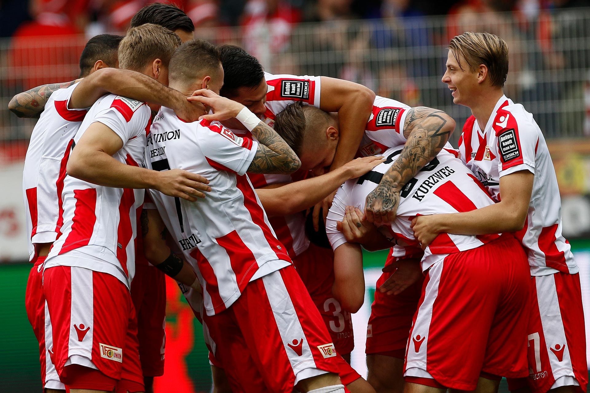 Spieler einer Fußballmannschaft feiern gemeinsam ein Tor auf dem Spielfeld.