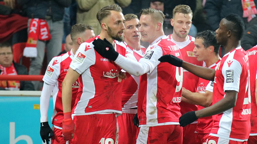 Die Spieler von Union Berlin freuen sich. Sie feiern ein Tor in der Bundesliga. Sie machen jubelnde Gesten.