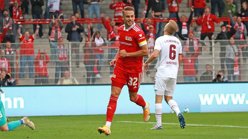 Spielszene im Fußball, ein Spieler jubelt nach einem Tor, Zuschauer im Hintergrund.