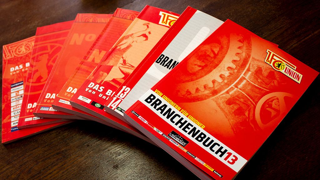 Eine Reihe von roten Broschüren mit dem Titel "Branchenbuch 13" und weiteren Titeln in verschiedenen Schriftgrößen.