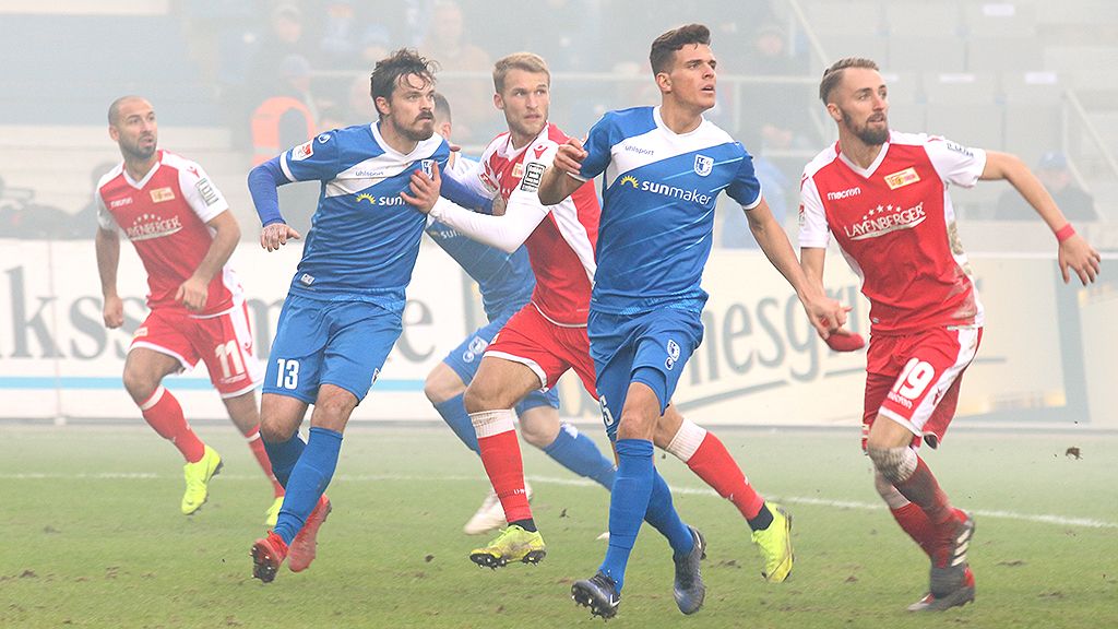 An exciting football scene with players in blue and red jerseys competing for the ball.