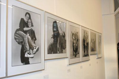 Eine Galeriewand mit mehreren gerahmten Schwarzweiß-Fotografien, die verschiedene Personen zeigen.