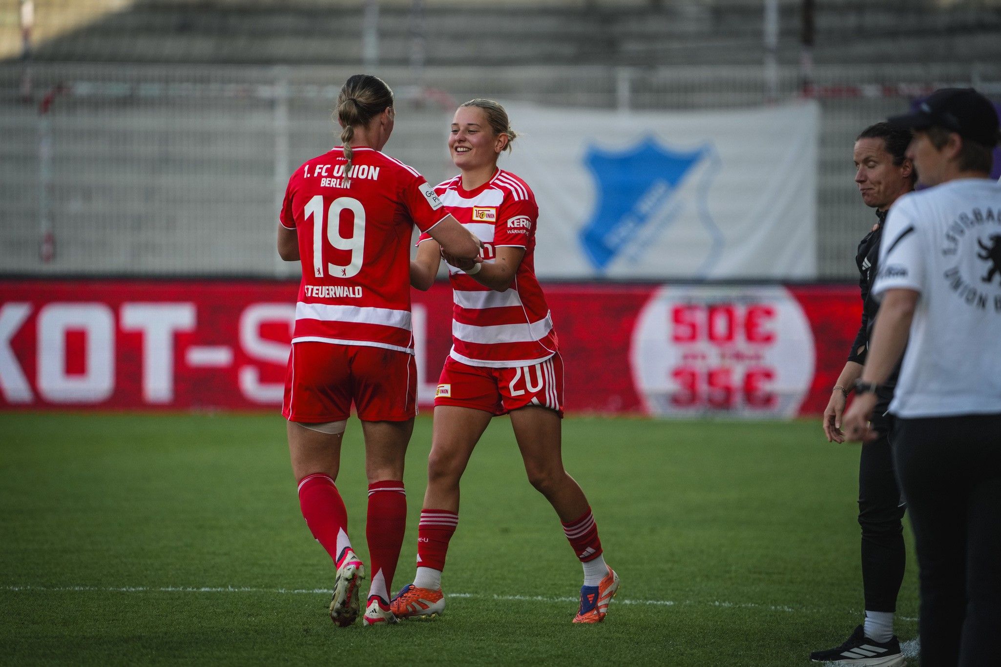 Zwei Spielerinnen des FC Union Berlin umarmen sich auf dem Spielfeld während eines Fußballspiels.