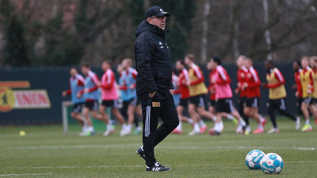 Ein Trainer beobachtet seine Spieler während des Trainings auf einem Fußballplatz.