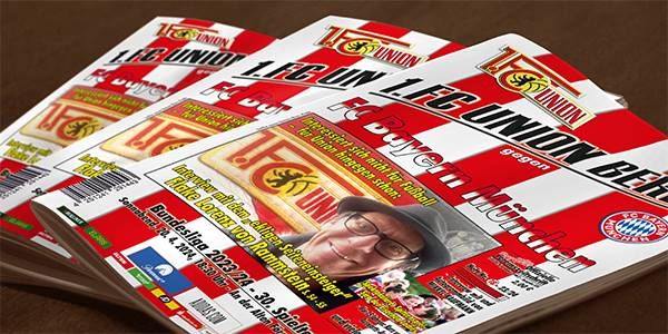 Drei Sportmagazine auf einem Tisch, die über ein Fußballspiel des 1. FC Union Berlin berichten.