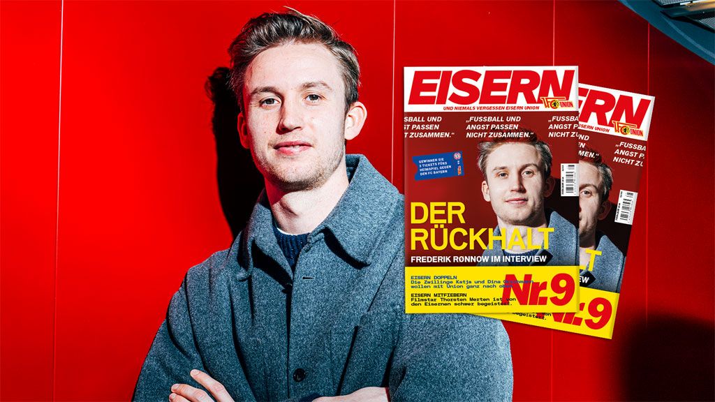 Eine Person steht vor rotem Hintergrund und blickt zur Kamera, während Magazine mit dem Titel "EISERN" im Vordergrund liegen.
