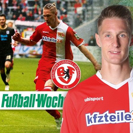 Ein Fußballspieler in rot-weißem Trikot läuft auf dem Spielfeld, während im Vordergrund ein Spieler mit lächelndem Gesicht steht.