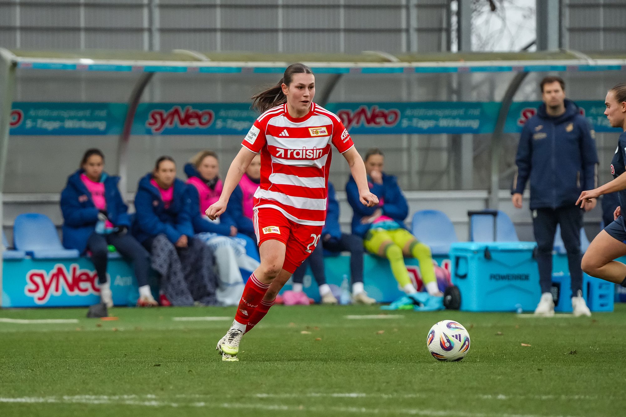 Eine Fußballspielerin im roten Trikot des 1. FC Union Berlin dribbelt den Ball auf dem Spielfeld.